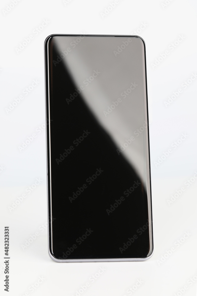 Black smartphone stands upright on a white background Black smartphone stands upright on a white background