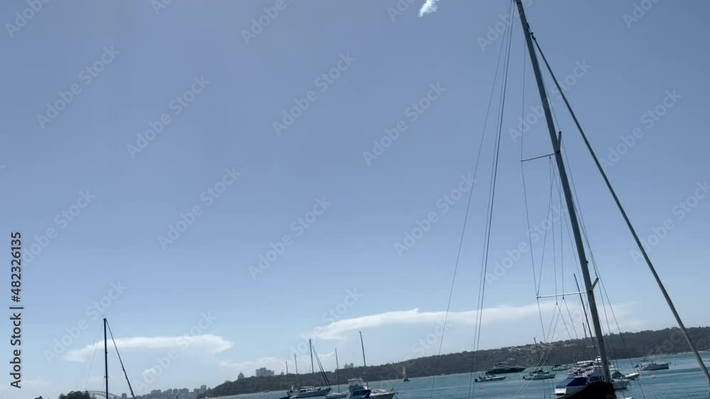 From yachts to skywritting, Panorama view of clean light-green sea waters with yachts and the background of Sydney CBD and Sydney Bridge, Hermitage Foreshore Walk, Sydney Australia From yachts to skywritting, Panorama view of clean light-green sea waters with yachts and the background of Sydney CBD and Sydney Bridge, Hermitage Foreshore Walk, Sydney Australia