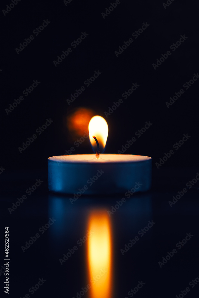 Burning candle with fading flame with reflex, black background Burning candle with fading flame with reflex, black background