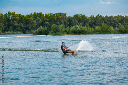 Skillful wakeboarder cutting water with edge of board creating splashes