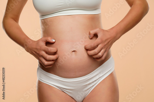 Cropped view of pregnant woman scratching her belly