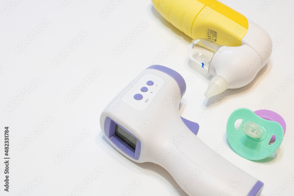 Non-contact infrared thermometer, electronic aspirator and pacifier. Flat lay, place for text.