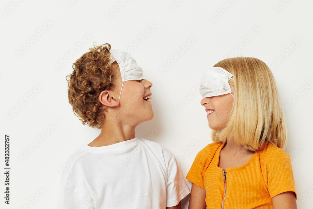 picture of positive boy and girl in a medical mask fun isolated background unaltered picture of positive boy and girl in a medical mask fun isolated background unaltered