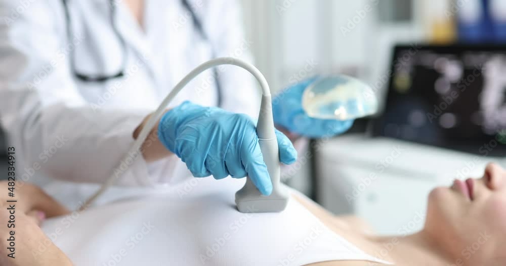 Doctor ultrasound probe breast silicone implant performs medical examination Doctor ultrasound probe breast silicone implant performs medical examination