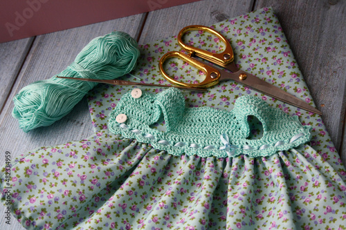 Crochet dress for a doll made of cotton yarn . Home needlework made of thread.