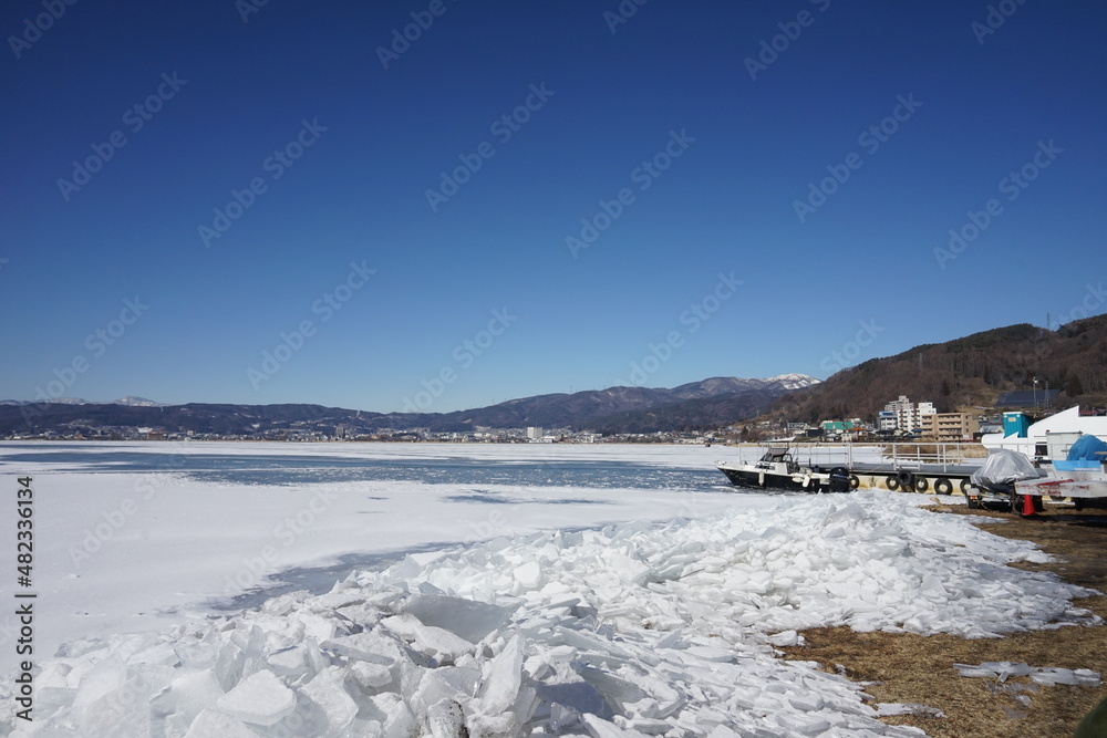 御神渡りが期待される凍った諏訪湖と湖岸に漂着した氷のブロック