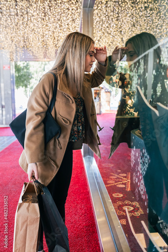 Woman looking into store window at Christmas