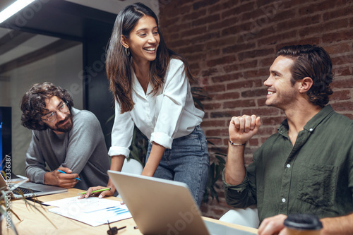 Smiling businesswoman with colleagues in meeting at coworking office photo