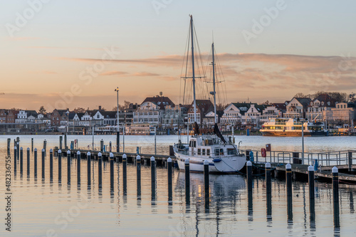 Germany, Schleswig-Holstein, Lubeck, Yacht moored in harbor at dusk photo