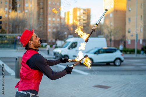 Street performer juggling flaming torches in city photo