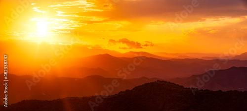 Dramatic orange sky over silhouette mountains in Montes de Malaga Natural Park at sunset, Andalucia, Spain, Europe