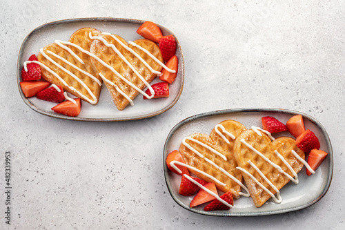 Belgian waffles in shape of heart with strawberries for Valentine day breakfast