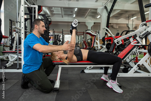 two young trainers a man and a woman train in the gym to maintain the health of their bodies.