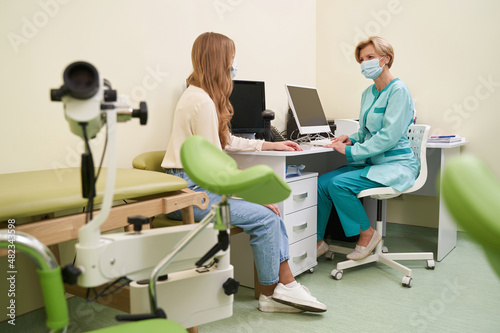 Young female person sitting opposite her doctor