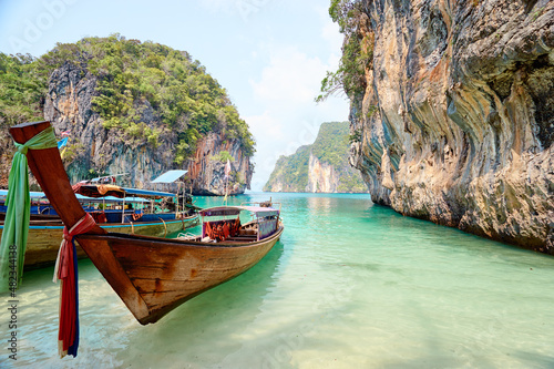Beautiful landscape with traditional longtail boats, rocks, cliffs, tropical beach. Krabi, Thailand.