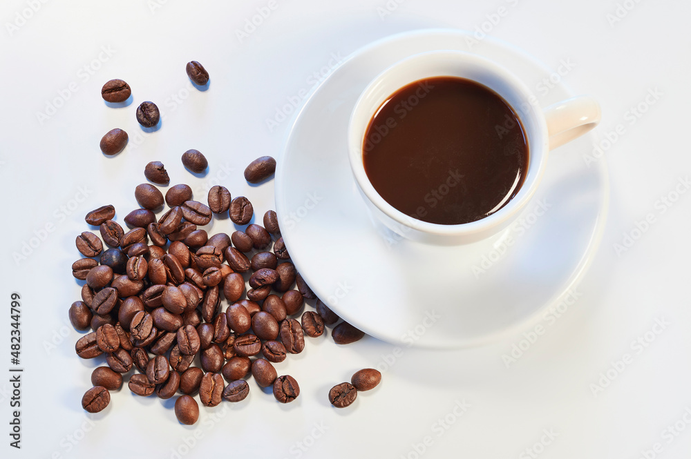 Obraz premium Cup of coffee and roasted coffee beans over white background