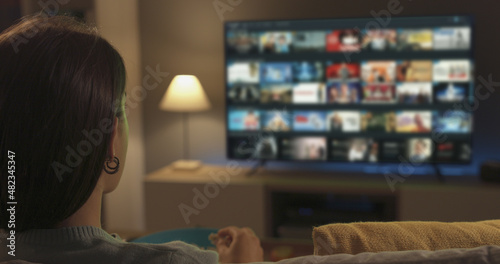 Young woman watching video on demand on her TV