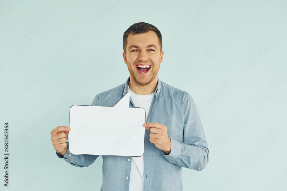In casual clothes. Man standing in the studio with empty signs for the text In casual clothes. Man standing in the studio with empty signs for the text