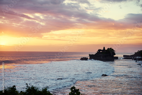 Beautiful balinese landscape. Ancient hinduism temple Tanah lot on the rock against sunset sky. Bali Island, Indonesia.