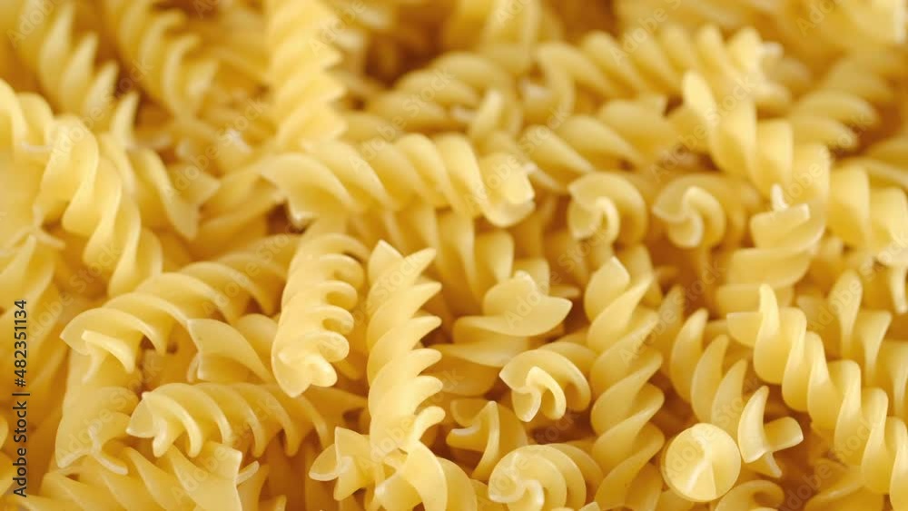 Rotating uncooked pasta . Stack of traditional dry raw macaroni. Nobody Rotating uncooked pasta . Stack of traditional dry raw macaroni. Nobody