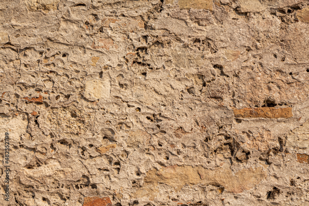 Beautiful texture of an old wall from orange stones with cracks