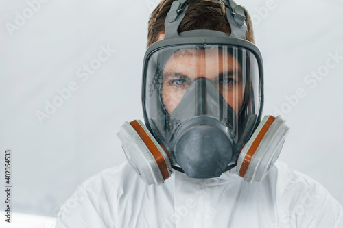Portrait of man in the protective mask. Worker in uniform is in the auto service © standret