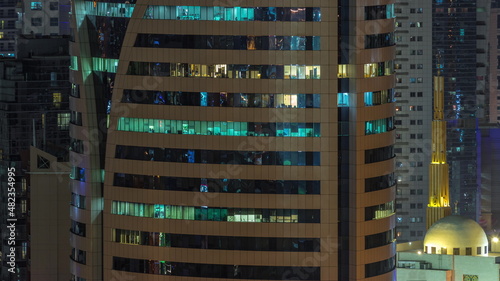 Mosque and skyscrapers in Barsha Heights district with glowing windows in office tower aerial night timelapse