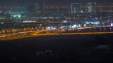 Dubai skyline with villa houses and construction site of new towers on a background aerial night timelapse.