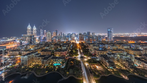 Panorama of skyscrapers in Barsha Heights district and low rise buildings in Greens district aerial night timelapse.