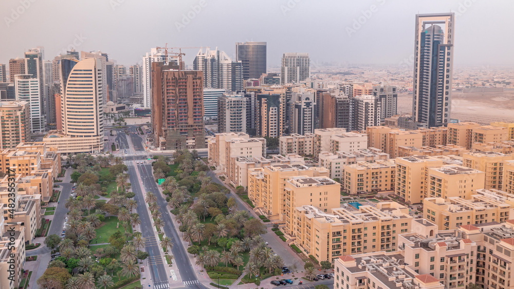 Obraz premium Skyscrapers in Barsha Heights district and low rise buildings in Greens district aerial timelapse. Dubai skyline