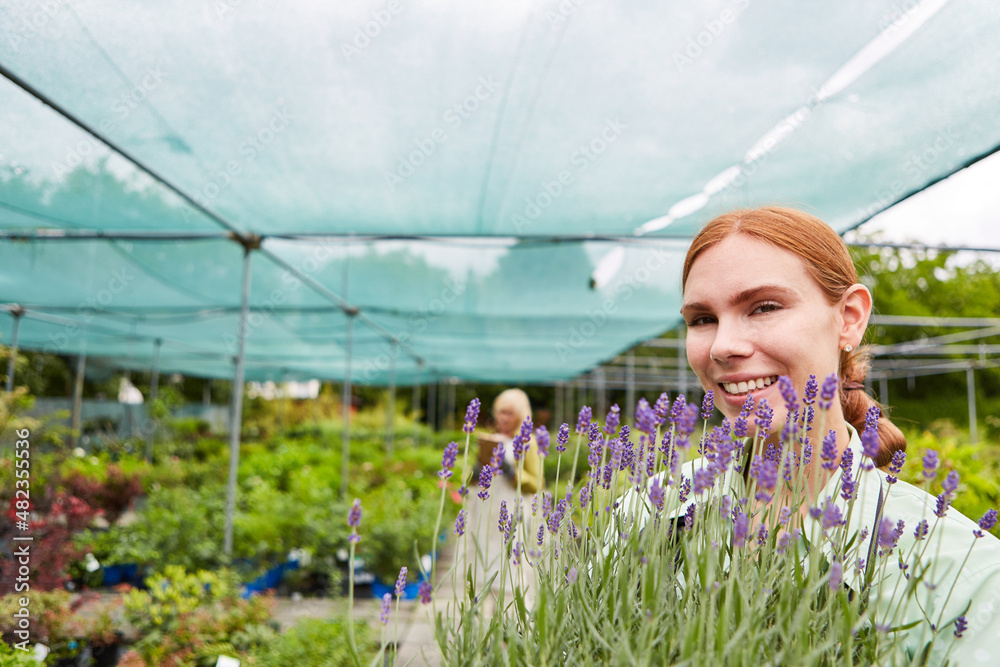Gardener trainee with flowers and plants in the garden center Stock ...