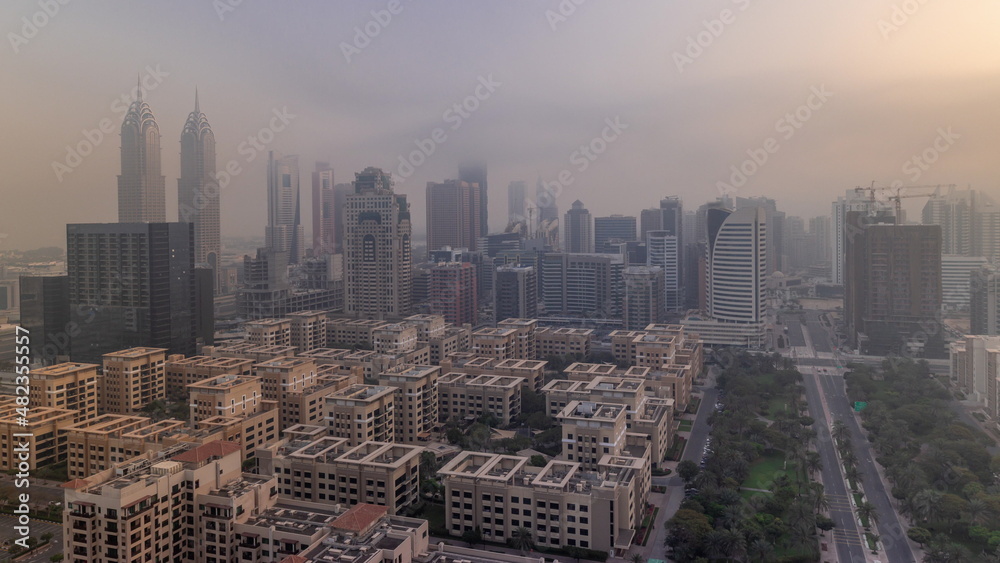 Fototapeta premium Skyscrapers in Barsha Heights district and low rise buildings in Greens district aerial timelapse. Dubai skyline