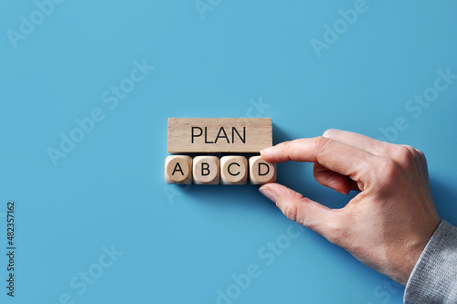 Wooden cubes with the word plan and options A, B, C, and D. Choosing option D from other possible options
