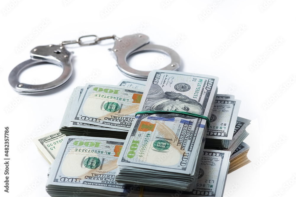 A dollars in bundles on white background with handcuffs crime fraud concept business pandemic