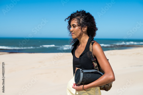 Woman walking with bluetooth speaker along coast