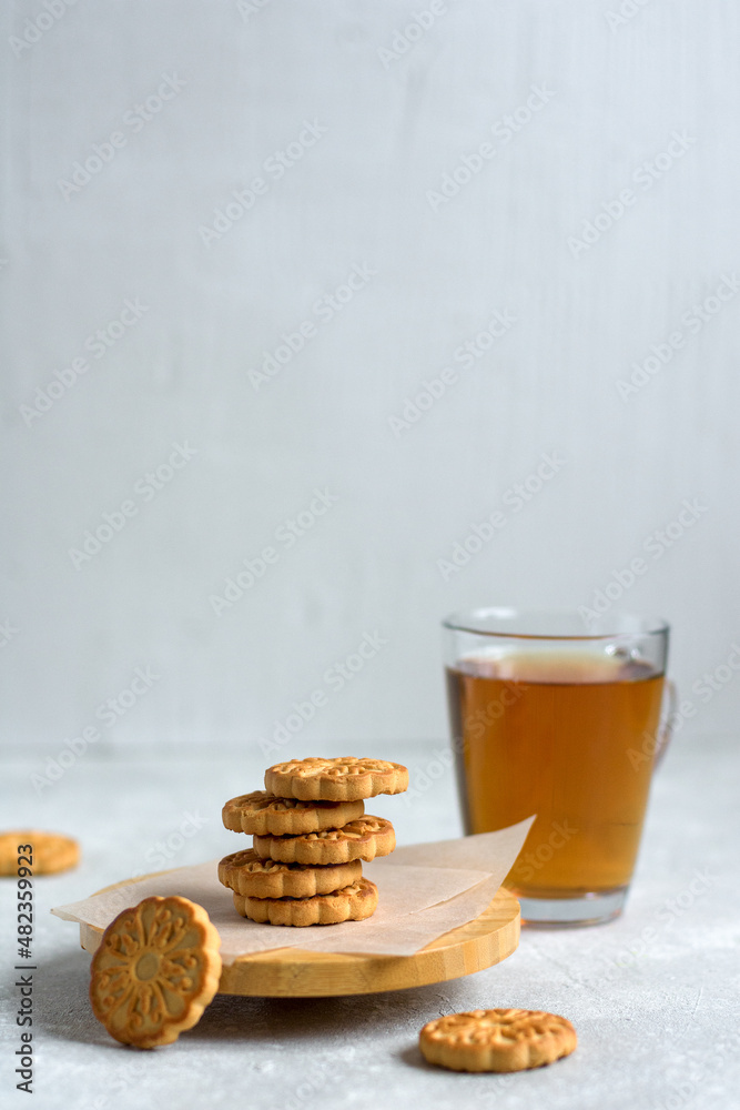 Cookies on a tray stacked against a mug of tea and a light gray background Cookies on a tray stacked against a mug of tea and a light gray background