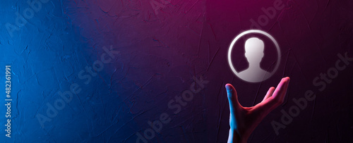 Businessman in suit holding out hand icon of user. Internet icons interface foreground. global network media concept contact on virtual screens  copy space.Neon banner purple blue light.