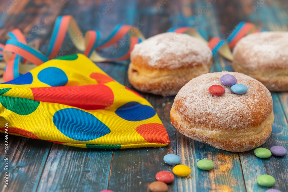 Three Doughnuts with colorful decoration on a wooden table