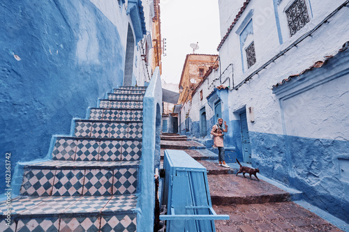 Traveling young woman on the street in medina of blue town Chefchaouen, Morocco.