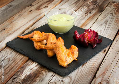 Homemade chicken wings with dip and red onion. photo