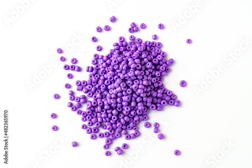 purple beads are scattered on a white surface. isolate. sale of accessories for creativity and needlework.