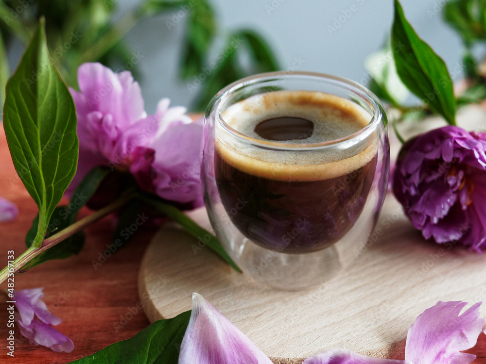 Closeup of a glass of coffee with flowers Closeup of a glass of coffee with flowers