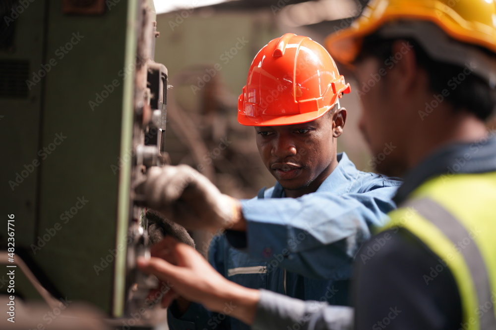 Portrait of Professional Heavy Industry Engineer / Worker Wearing Safety Uniform, Goggles and Hard Hat. In the Background Unfocused Large Industrial Factory Portrait of Professional Heavy Industry Engineer / Worker Wearing Safety Uniform, Goggles and Hard Hat. In the Background Unfocused Large Industrial Factory
