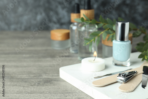 Concept of nail care with manicure accessories on gray wooden table