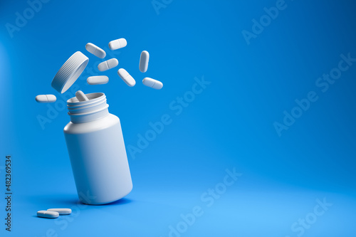 White pills from plastic medicine bottle on blue background with copy space. Medicine and health concept. 3d rendering.