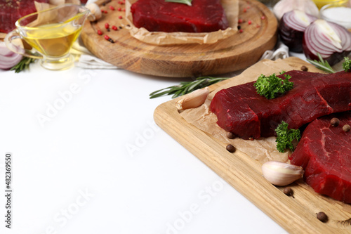 Concept of tasty food with raw beef steaks on white background