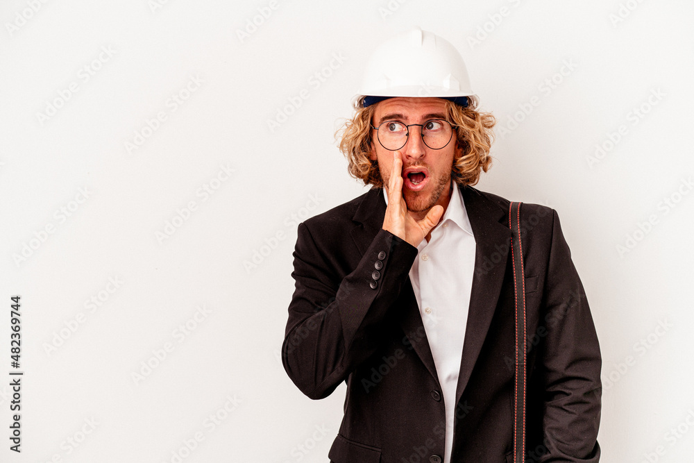Young architect caucasian man with helmet isolated on white background is saying a secret hot braking news and looking aside Young architect caucasian man with helmet isolated on white background is saying a secret hot braking news and looking aside