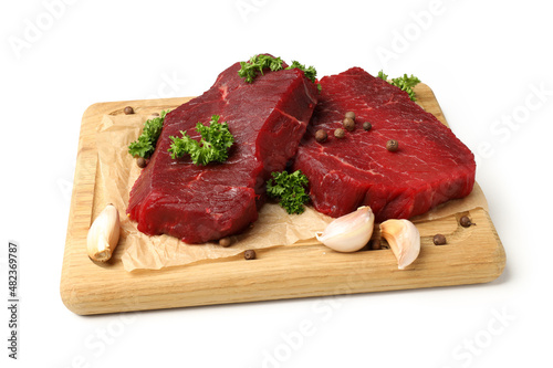 Board with raw beef steaks isolated on white background
