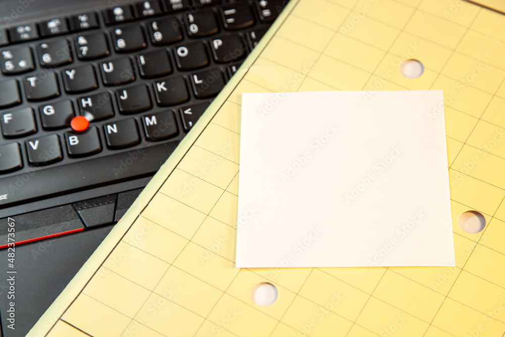 Laptop keyboard and yellow Folder with empty sticky note message, paper note. blank message note for text Laptop keyboard and yellow Folder with empty sticky note message, paper note. blank message note for text