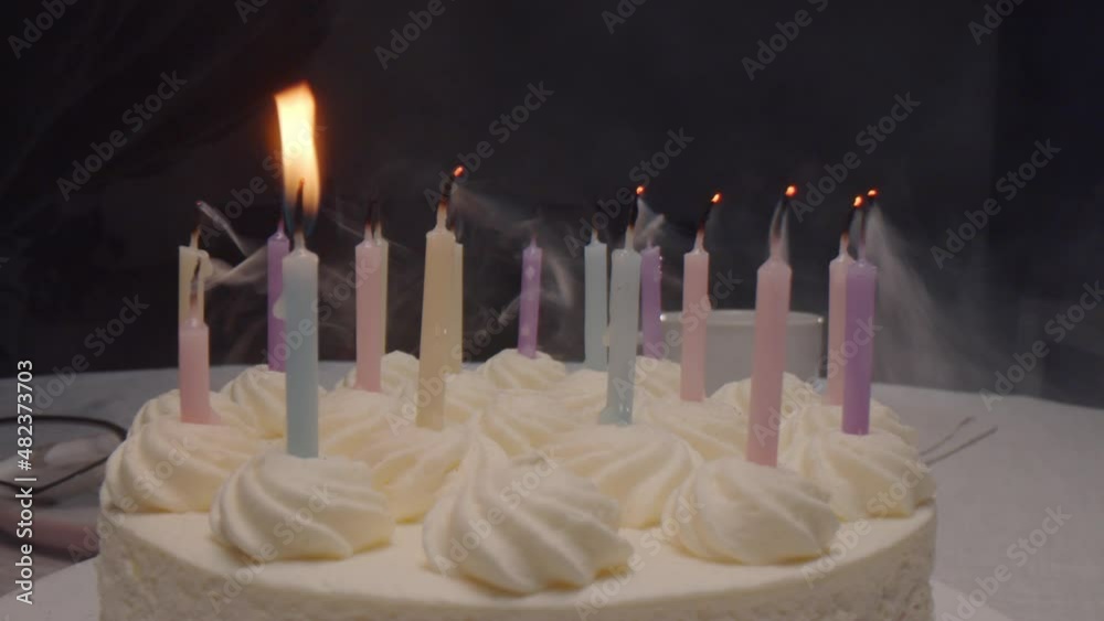 Close up zoom out shot of candles being blown out on birthday cake